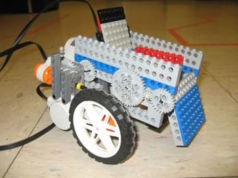 A photograph shows what looks like a chair on wheels with gears and sensors, made from a LEGO robot kit and LEGO pieces.