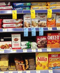 A photograph shows four shelves in a store containing packaged cookies and crackers.