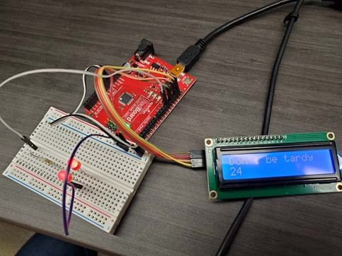 A picture of the physical warning system Arduino circuit that shows the red LED lights on and the LCD screen displaying “Don’t be tardy,” with a countdown from 30. 