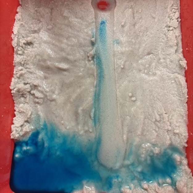 An image illustrating the movement of pollutants (represented by food coloring) as they travel downstream in a bayou. Some pollutants settle along the bayou's banks, while most disperse across the surrounding low-lying land areas. An image illustrating the movement of pollutants (represented by food coloring) as they travel downstream in a bayou. Some pollutants settle along the bayou's banks, while most disperse across the surrounding low-lying land areas.