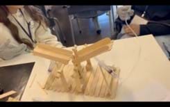 A photo showing a popsicle stick bridge with a flat, rectangular base. There is a syringe on each side of the base that is being held together with popsicle sticks attached to base and syringe at an angle. Each syringe is attached to a plastic tube that had an additional syringe on the other end to control movement through the tube. The parts of the syringe that get push and pulled are directed toward the top portion of the bridge. The top portion of the bridge has 2 leaf-like parts that lift when the syringes are pushed on each side of the top platform, and when the syringes are pulled, the platform lowers. A photo showing a popsicle stick bridge with a flat, rectangular base. There is a syringe on each side of the base that is being held together with popsicle sticks attached to base and syringe at an angle. Each syringe is attached to a plastic tube that had an additional syringe on the other end to control movement through the tube. The parts of the syringe that get push and pulled are directed toward the top portion of the bridge. The top portion of the bridge has 2 leaf-like parts that lift when the syringes are pushed on each side of the top platform, and when the syringes are pulled, the platform lowers.