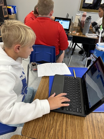 A photo showing a student using their custom code to code the micro:bit.