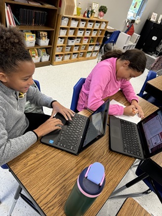 A photo showing two students working together to create their own code and prototype and coding a micro:bit.