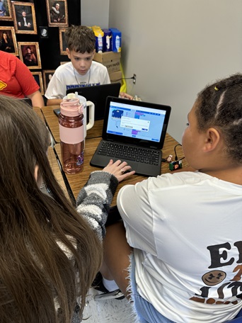 A photo showing two students working together to create their own code and prototype and coding a micro:bit.