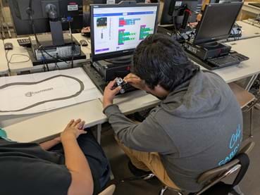 A photo showing a group working on their code for the ultimate challenge. A photo showing a group working on their code for the ultimate challenge.