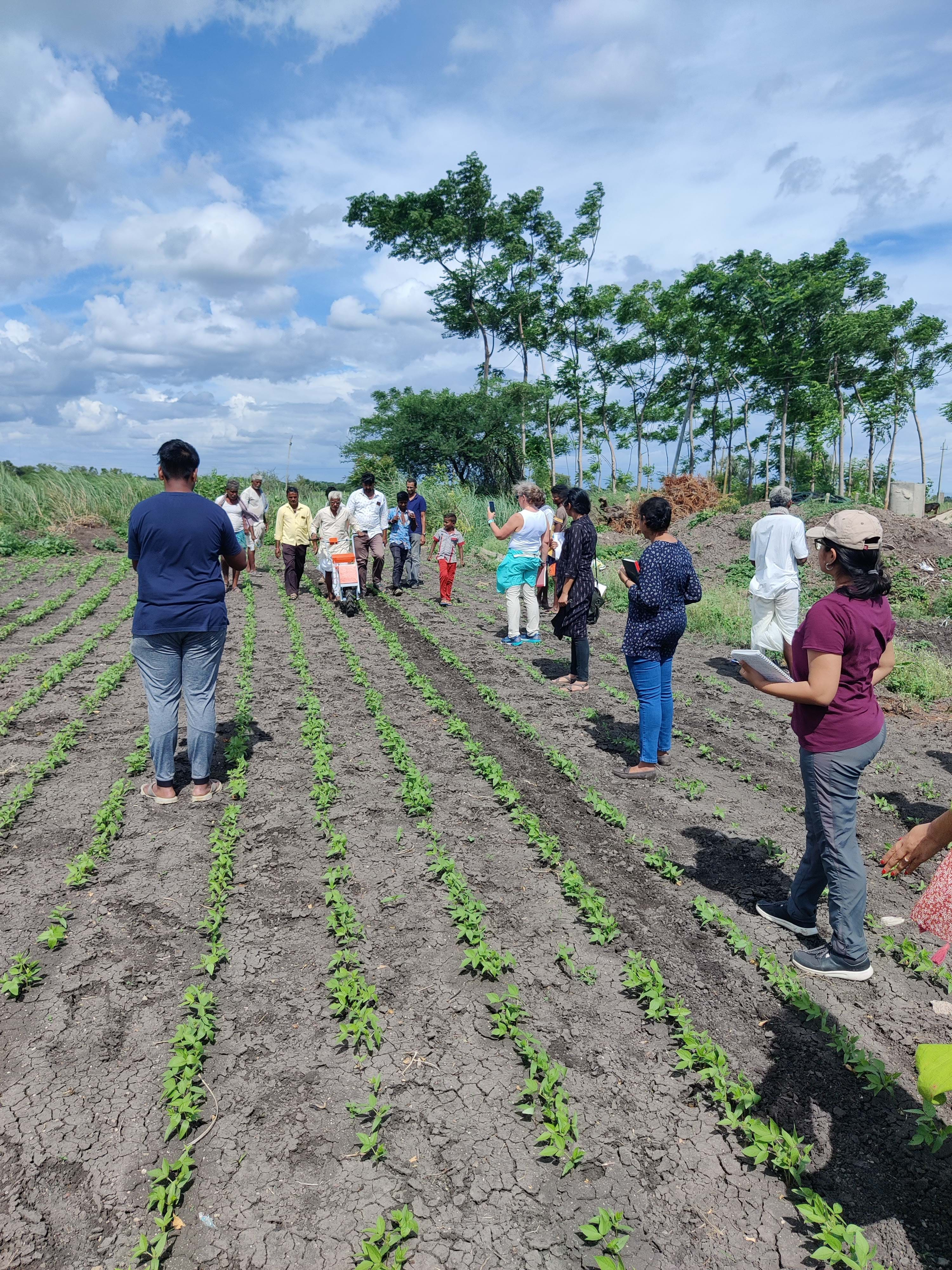 A photo of a group of people standing in a field.