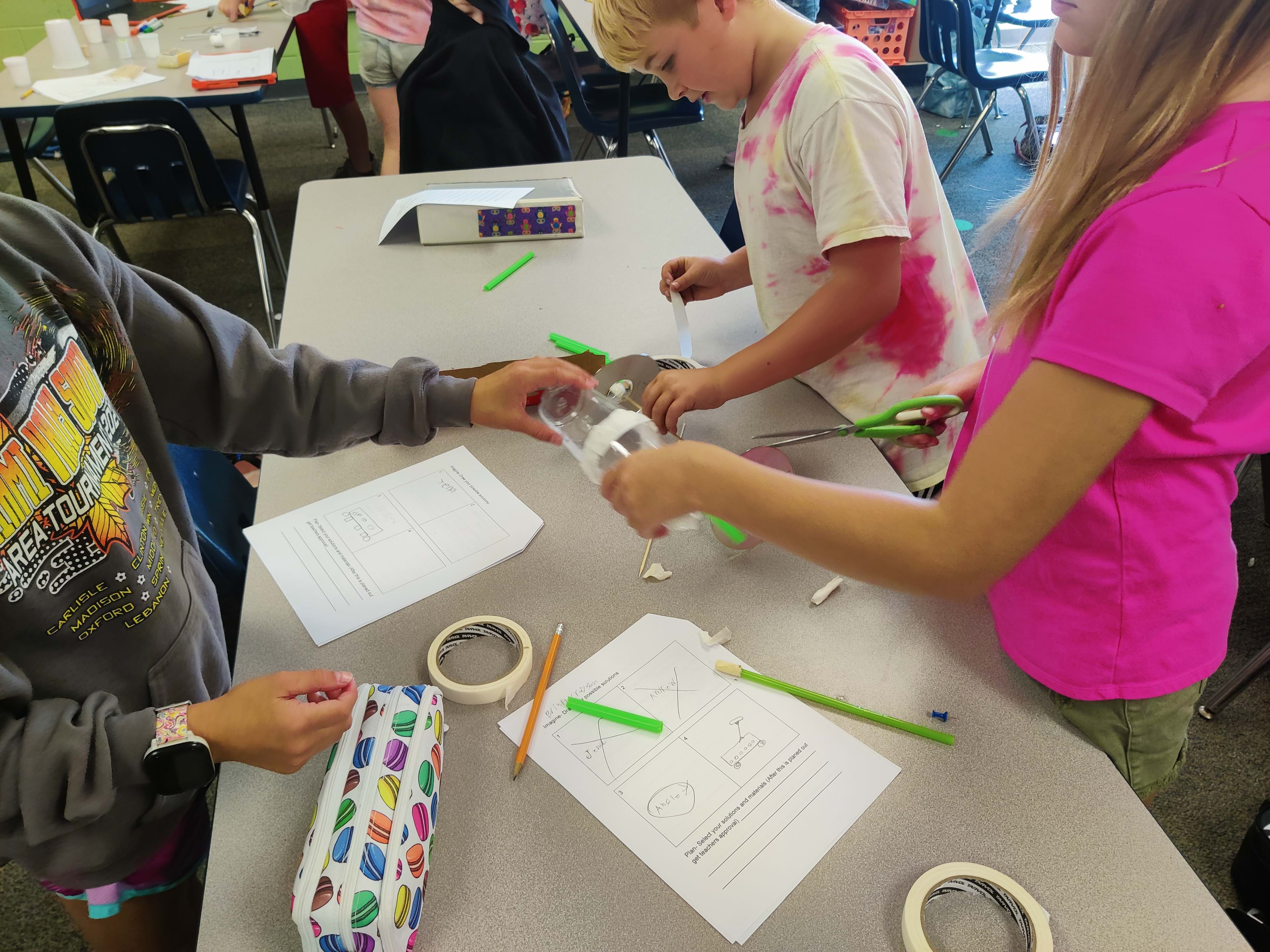 A photo of a group of young students working on their project.