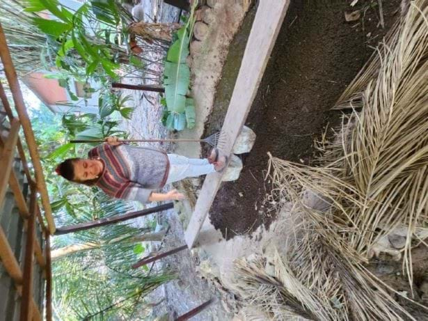 A photo showing Tatiana Vera Ramos at the Community Transformation Center (CTC) tending to her worms and soil. She is in charge of the aquaponics system, medicinal plants educational program, and composting efforts. She is demonstrating how to manage the vermiculture used at Tekoati to help ensure food security for local communities.