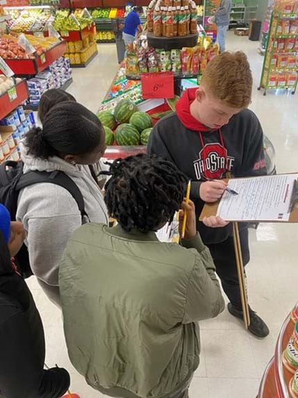 A photo showing four students holding clipboards investigating the layout of the La Michoacana Mexican Market #10 in Huber Heights, Ohio.