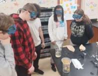 A photo of five students standing around a lab desk. There are three beakers, two of which have funnels in them. Two pieces of filter paper and a strip of toilet paper are also on the desk. A photo of five students standing around a lab desk. There are three beakers, two of which have funnels in them. Two pieces of filter paper and a strip of toilet paper are also on the desk.