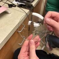 A photo showing a student holding a piece of round glass substrate. A photo showing a student holding a piece of round glass substrate.