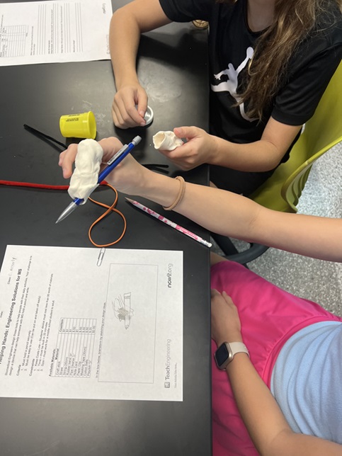 A photo showing students designing and building their device.  