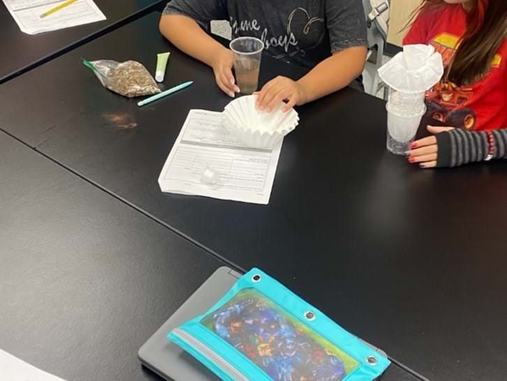 A photo showing students building water filtration systems.