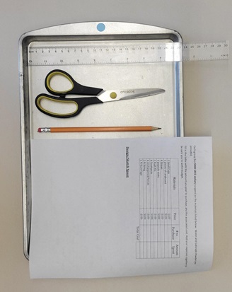 A photo of a metal tray holding scissors, a ruler, a piece of paper, and a pencil. 