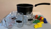 A photo of kitchen items used for the experiment, including a pot, half-pint Mason jars, a measuring cup, some clothespins, and cloth pegs.