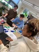 A photo showing three students referencing the codon wheel as they organize the amino acids they will use to construct a model of a polypeptide. A photo showing three students referencing the codon wheel as they organize the amino acids they will use to construct a model of a polypeptide.